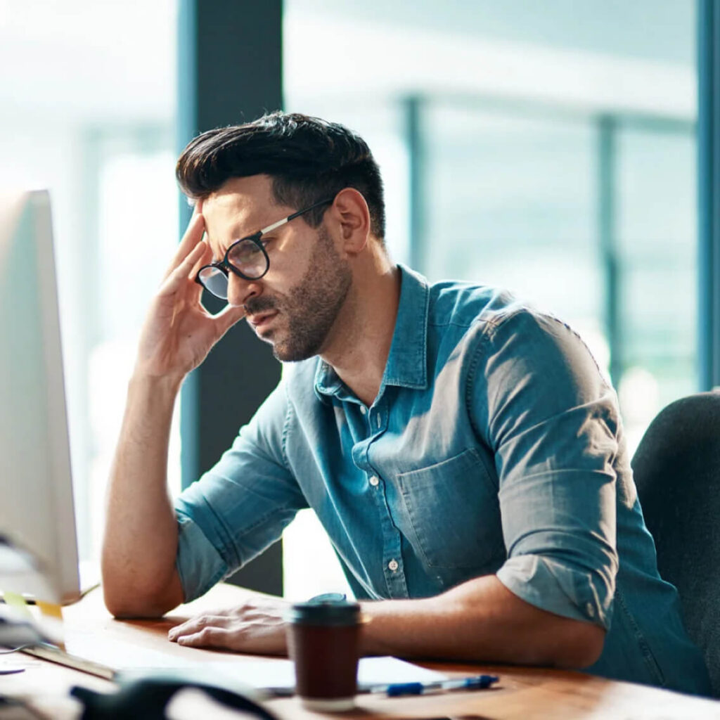 Man in glasses frustrated at his computer.