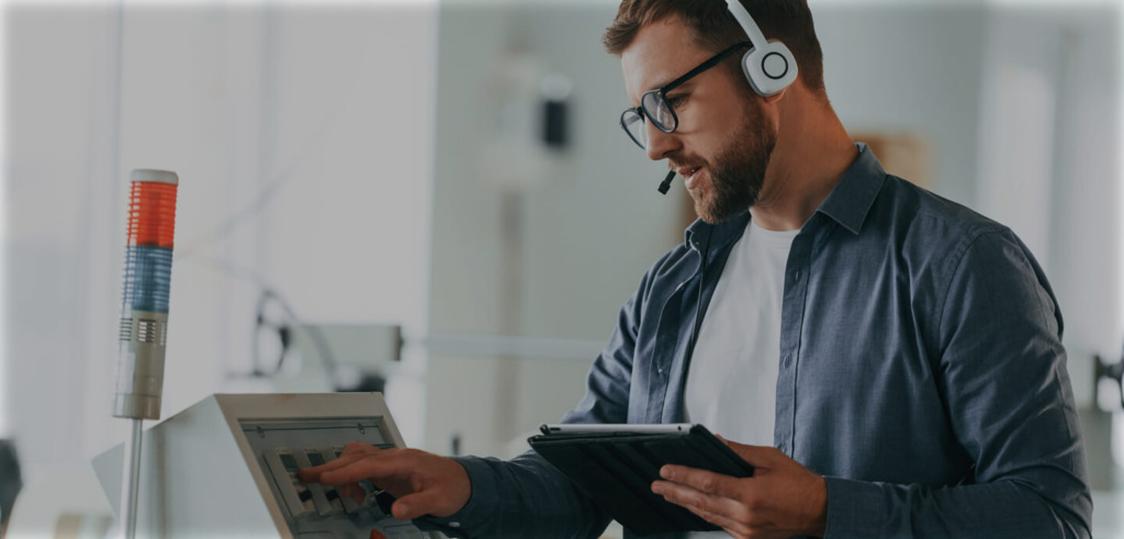 Man having a conversation via a headset while working on a tablet.